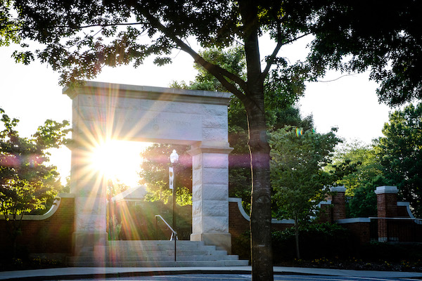 Photo by Ken Bennett of the arch on the Quad with the sun shining behind