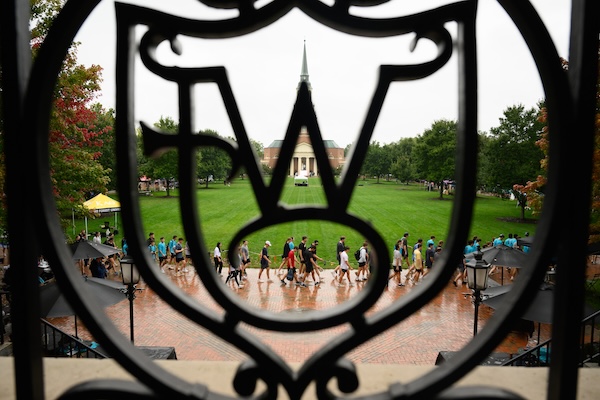 Hit the Bricks runners through iron railing on the Quad