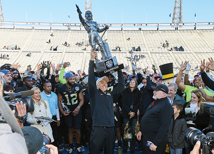 Dave Clawson holding trophy after bowl victory